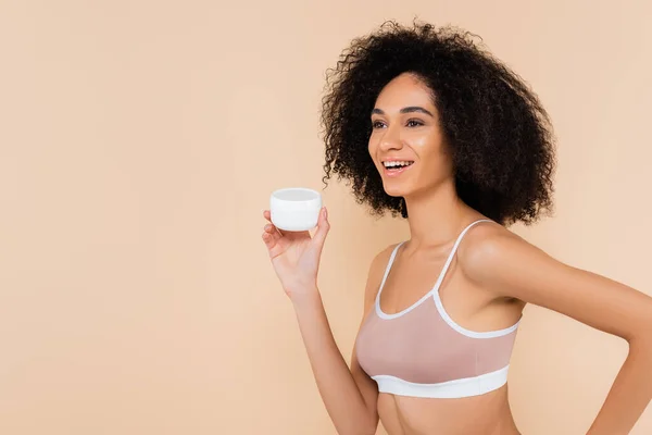 Joyful African American Woman Looking Away While Holding Cosmetic Cream — Stock Photo, Image