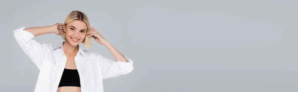 Mujer Rubia Camisa Blanca Sonriendo Cámara Mientras Fija Cabello Aislado — Foto de Stock