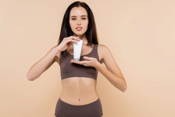 Mooie Vrouw Ondergoed Tonen Cosmetische Crème Geïsoleerd Beige — Stockfoto