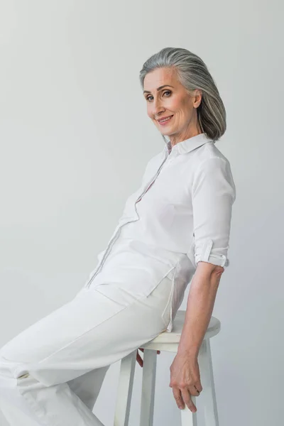 Grey Haired Woman Smiling Camera White Chair Isolated Grey — Stock Photo, Image