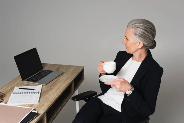 Kobieta Średnim Wieku Filiżanką Kawy Siedzi Obok Laptopa Notebooka Stole — Zdjęcie stockowe