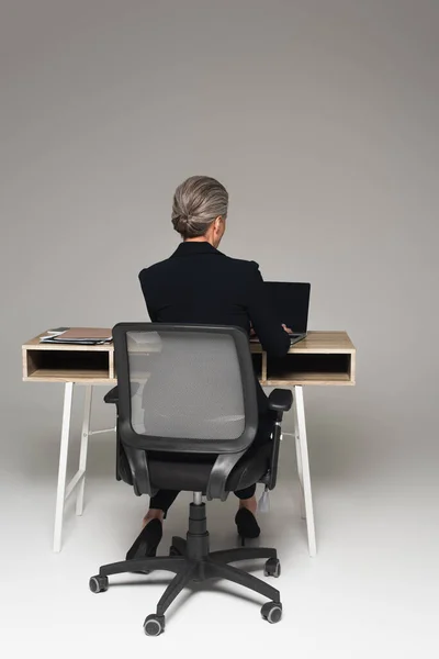 Back View Middle Aged Manager Using Laptop Paperwork Table Grey — Stock Photo, Image