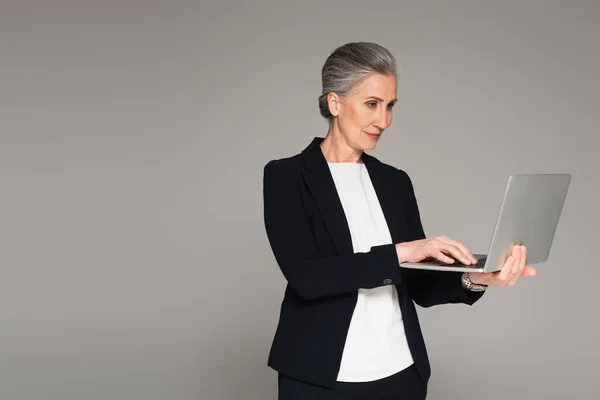 穿着正装的女商人使用的笔记本电脑是灰色的 — 图库照片