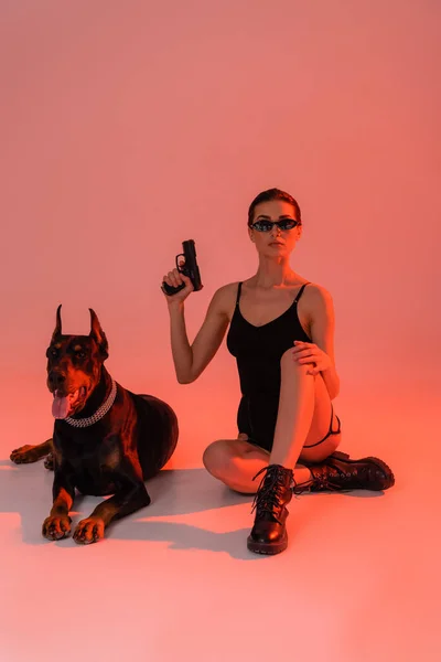 Doberman Dog Armed Woman Sitting Pink Background Yellow Light — Stock Photo, Image