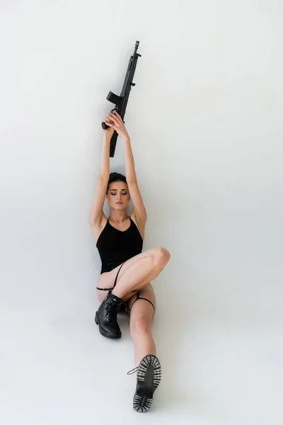 Sensual Woman Holding Rifle Raised Hands While Sitting Closed Eyes — Stock Photo, Image