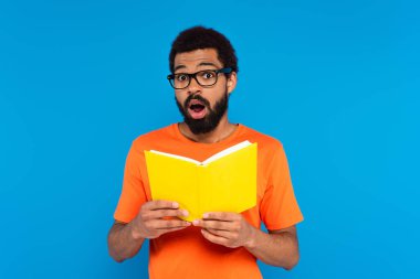 Şok olmuş Afrikalı Amerikalı bir adam kitap okuyor.
