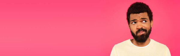 uncertain african american man isolated on pink, banner