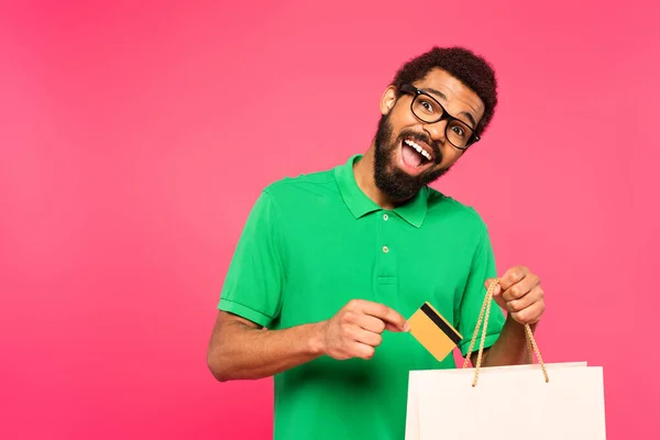 Hombre Afroamericano Asombrado Gafas Con Tarjeta Crédito Cerca Bolsa Aislada —  Fotos de Stock