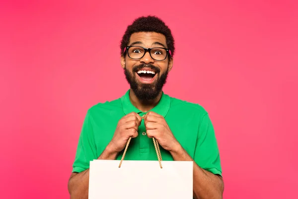 Stupito Afro Americano Uomo Occhiali Tenendo Shopping Bag Isolato Rosa — Foto Stock