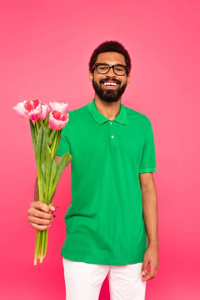 Hombre Afroamericano Feliz Gafas Polo Verde Sosteniendo Tulipanes Aislados Rosa — Foto de Stock