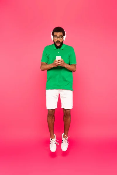 Longitud Completa Hombre Afroamericano Sorprendido Gafas Auriculares Con Teléfono Inteligente — Foto de Stock