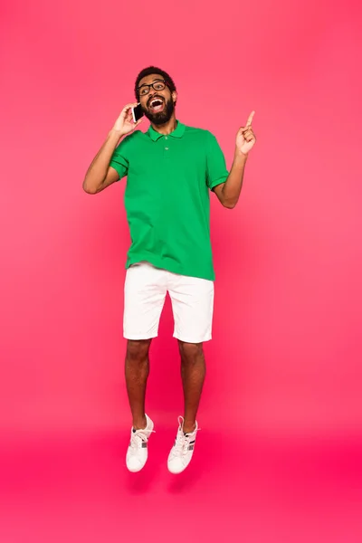 Longitud Completa Hombre Afroamericano Emocionado Gafas Saltando Mientras Habla Teléfono — Foto de Stock