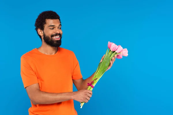 Hombre Afroamericano Feliz Sosteniendo Tulipanes Rosados Aislados Azul —  Fotos de Stock