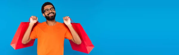 Glücklicher Afrikanisch Amerikanischer Mann Mit Brille Einkaufstaschen Isoliert Auf Blauem — Stockfoto