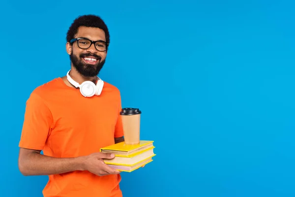 Glad Amerikansk Mann Trådløse Hodetelefoner Som Holder Bøker Med Papirkopp – stockfoto