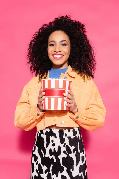 Fröhliche Afroamerikanerin Hält Eimer Mit Popcorn Auf Rosa — Stockfoto