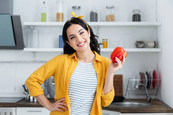 Sonriente Morena Mujer Sosteniendo Rojo Pimiento Mientras Pie Con Mano — Foto de Stock