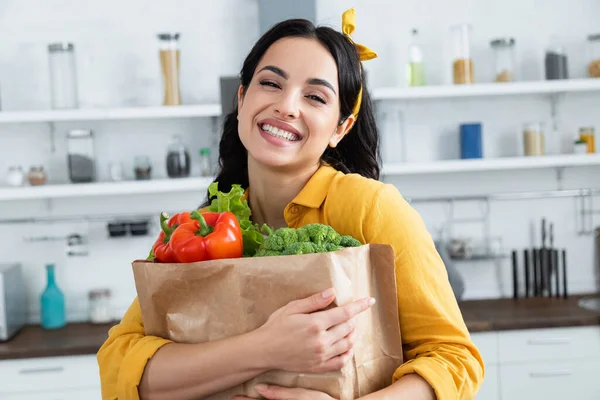 Happy Brunette Wanita Memeluk Kantong Kertas Dengan Bahan Makanan Segar — Stok Foto