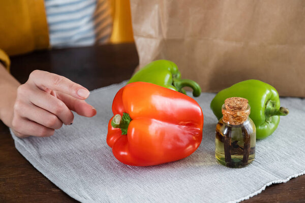cropped view of woman reaching bell peppers 