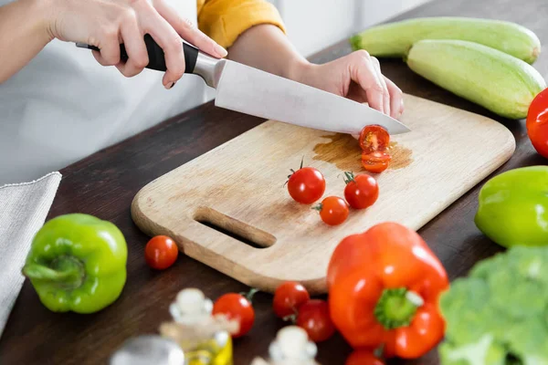 Vista Ritagliata Della Donna Che Taglia Pomodorini Ciliegini Sul Tagliere — Foto Stock