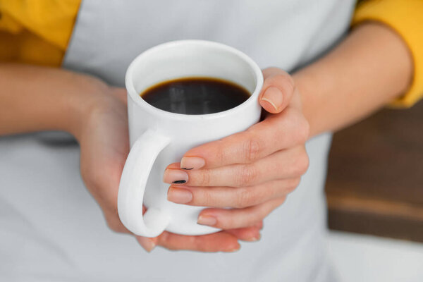 cropped view of woman holding white cup of coffee 