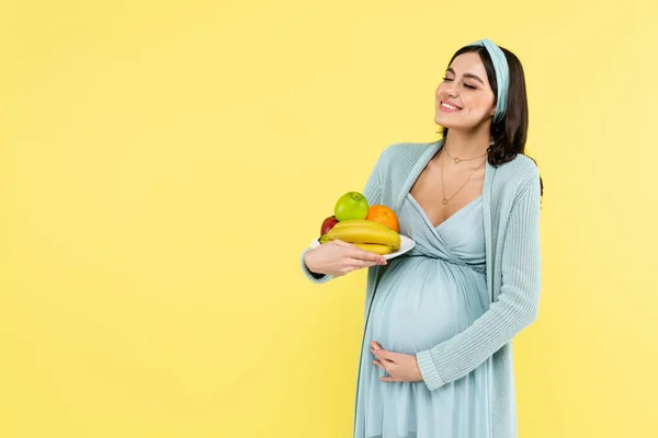 Smiling Pregnant Woman Holding Plate Ripe Fruits Isolated Yellow — Stock Photo, Image