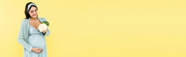 Счастливая Беременная Женщина Держит Свежий Брокколи Цветной Капусты Изолированы Желтый — стоковое фото