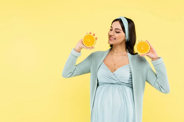 Cheerful Pregnant Woman Holding Halves Ripe Orange Isolated Yellow — Stock Photo, Image