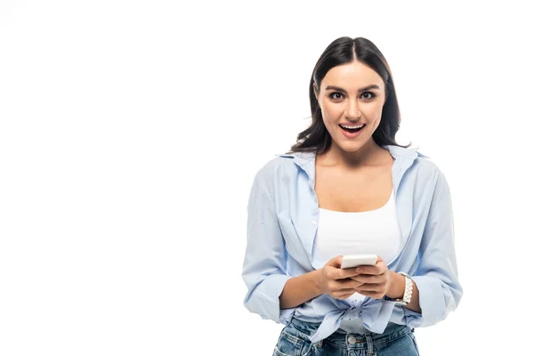 Mujer Asombrada Mirando Cámara Mientras Mensajería Teléfono Inteligente Aislado Blanco — Foto de Stock