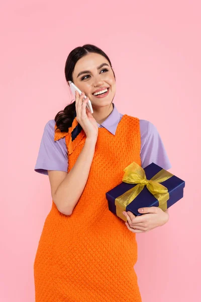Mulher Feliz Segurando Caixa Presente Enquanto Fala Smartphone Isolado Rosa — Fotografia de Stock