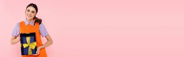 Брюнетка Женщина Улыбается Камеру Показывает Подарочные Коробки Изолированы Розовый Баннер — стоковое фото