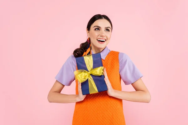 Upphetsad Kvinna Tittar Bort Samtidigt Hålla Presentförpackning Isolerad Rosa — Stockfoto