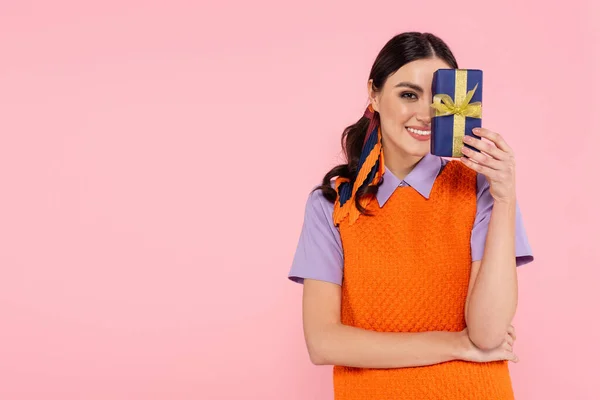 Morena Sonriendo Mientras Oscurece Cara Con Caja Regalo Aislada Rosa — Foto de Stock