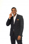 usmívající se africký americký podnikatel s vlajkou Igbt namalované na tváři mluví na smartphone izolované na bílém