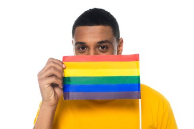 Afro-Amerikan adam beyaz üzerine izole edilmiş küçük bir lgbt bayrağıyla ağzını kapatıyor.