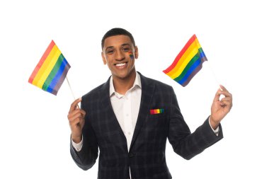african american transgender woman holding lgbt flags while smiling at camera isolated on white clipart