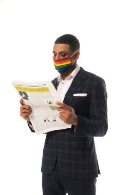 Igbt renklerinde Afro-Amerikan iş adamı. Tıbbi maske, beyazlar üzerinde izole edilmiş gazete okuyor.