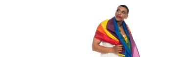 Afro-Amerikan transseksüel adam, lgbt bayrağıyla kaplanmış, beyaz pankartta izole görünüyor.