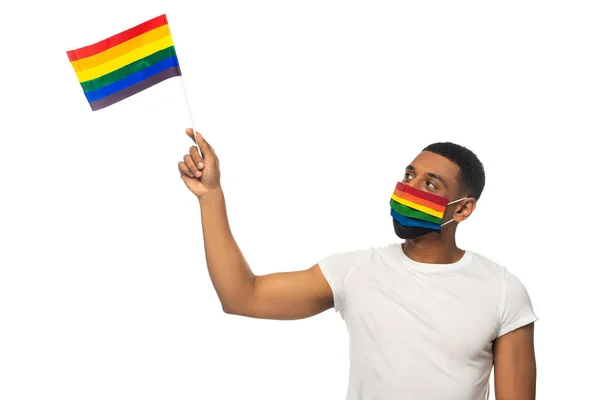 身穿彩虹色医疗面罩的非洲裔美国人 手持小Lgbt旗 与白色隔离 — 图库照片