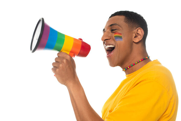 african american man with lgbt flag painted on face screaming in megaphone isolated on white