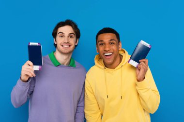 Mutlu ırklar arası dostların elinde pasaportları ve ellerinde uçak biletleri var.