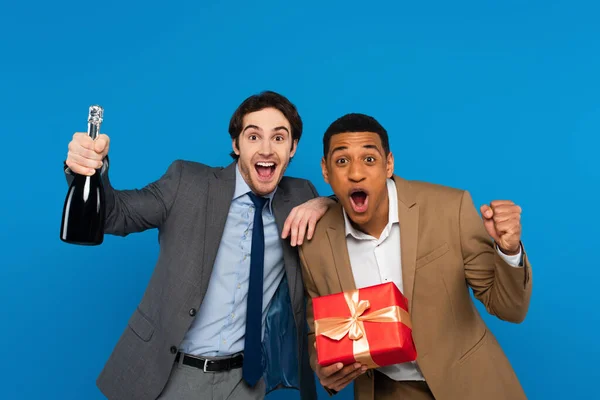 Glada Interracial Vänner Kostymer Ler Mot Kameran Och Håller Presentförpackning — Stockfoto