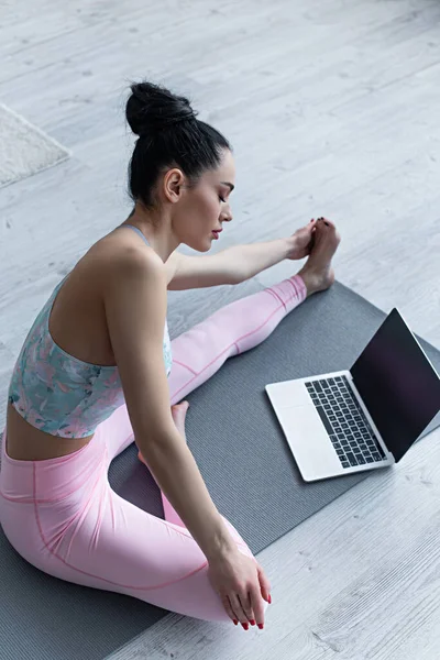 Sportive Woman Stretching Yoga Pose Laptop Blank Screen — Stock Photo, Image