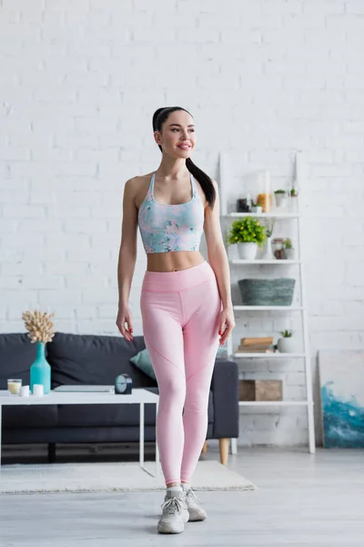 Leende Kvinna Sport Behå Och Leggings Tittar Bort Hemma — Stockfoto