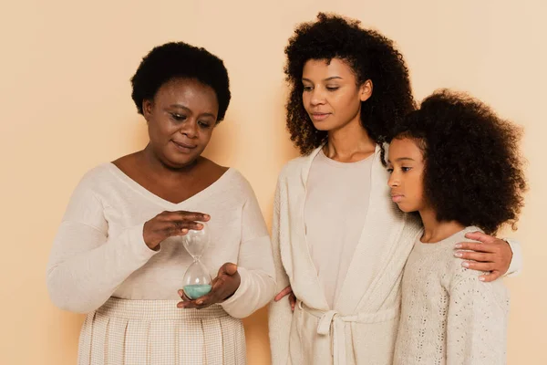 African American Grandmother Holding Sandglass Daughter Granddaughter Standing Nearby Beige — Stock Photo, Image