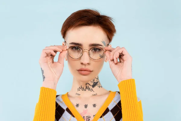 Mujer Joven Tatuada Ajustando Gafas Aisladas Azul — Foto de Stock