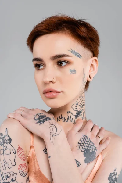 Jovem Mulher Com Tatuagens Olhando Para Longe Isolado Cinza — Fotografia de Stock