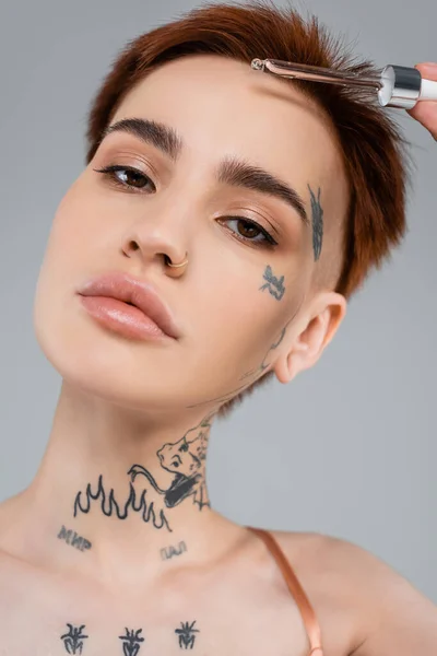 Giovane Donna Tatuata Possesso Pipetta Con Siero Isolato Grigio — Foto Stock