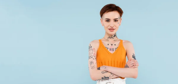 Pleased Tattooed Woman Orange Knitted Tank Top Standing Crossed Arms — Stock Photo, Image