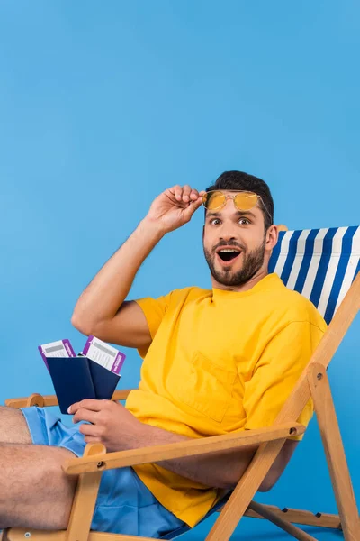 Excited Man Holding Sunglasses Passports Deck Chair Blue Background — Stock Photo, Image
